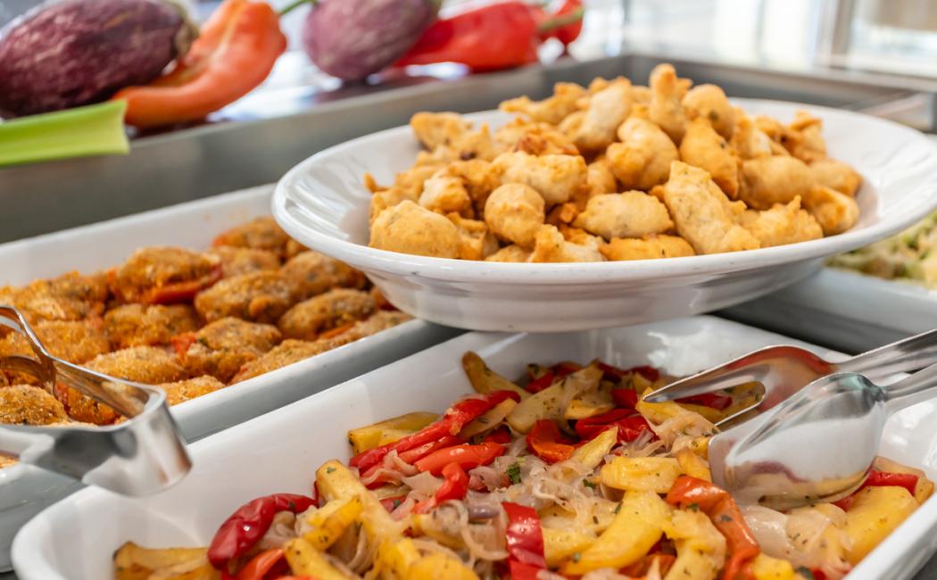 Buffet con verdure grigliate, bocconcini fritti e melanzane ripiene.