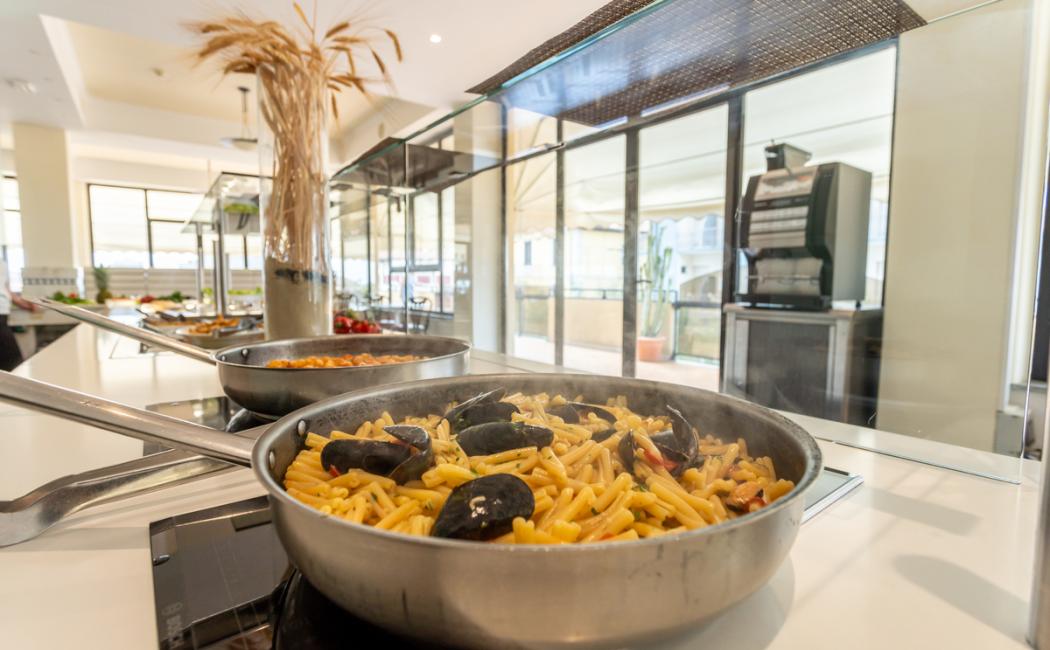Pasta con cozze in padella, servita su un buffet in un ristorante elegante.
